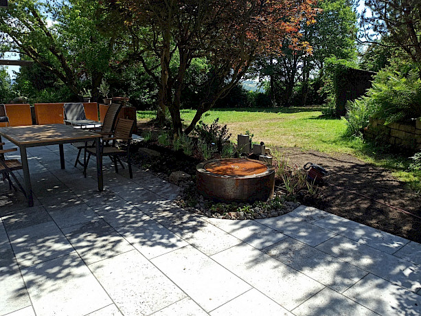 Terrasse mit Brunnen im Schatten von Bäumen